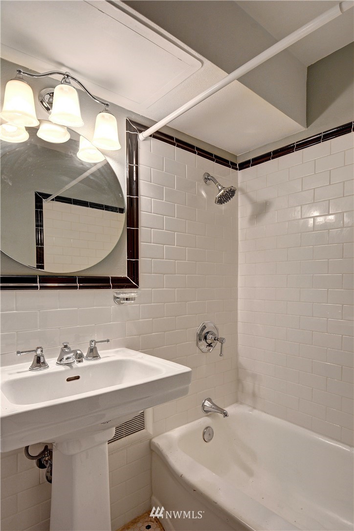 1105 Spring Street, Unit 610 Seattle, WA 98104 - Photo 9 of 12 a bathroom with a sink and a mirror