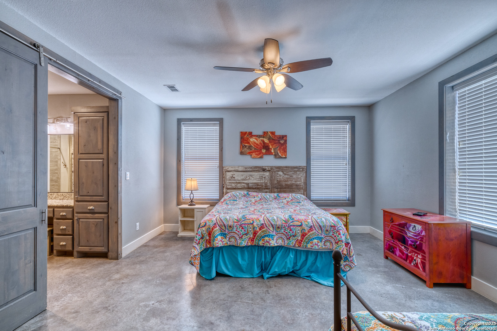 989 Mountain Valley Road Concan, TX 78838 - Photo 14 of 35 a bedroom with a bed and a chandelier