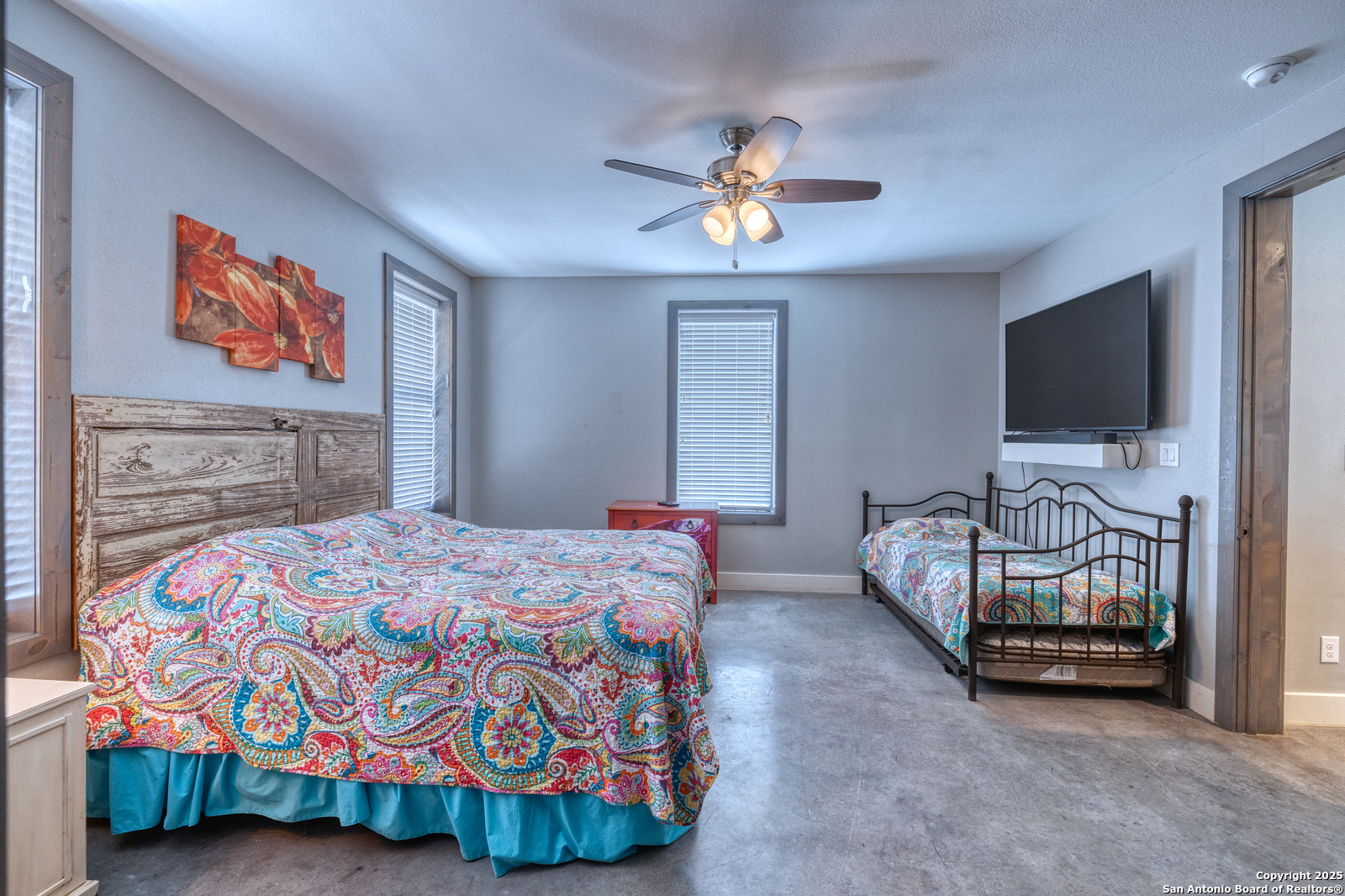 989 Mountain Valley Road Concan, TX 78838 - Photo 17 of 35 a bedroom with a bed and a flat screen tv