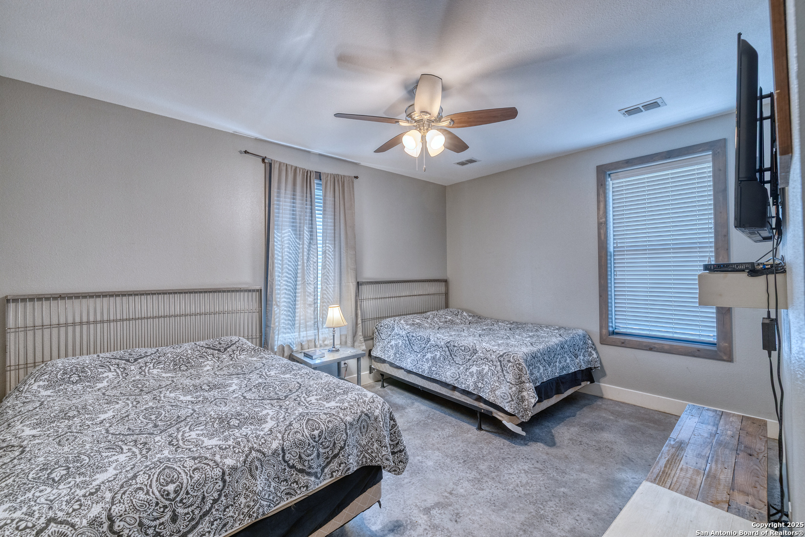 989 Mountain Valley Road Concan, TX 78838 - Photo 19 of 35 a bedroom with a bed chandelier and a window