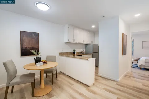 a kitchen with a dining table chairs and white cabinets