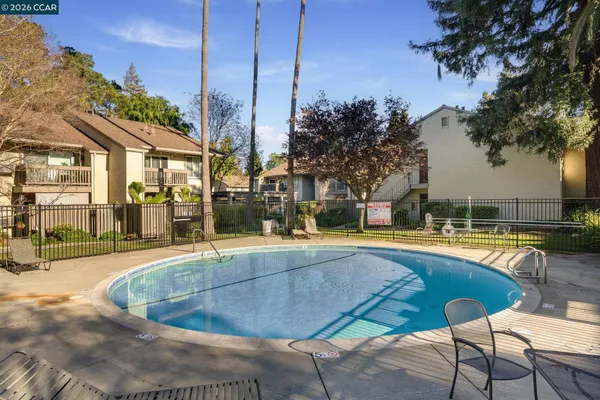 a view of a swimming pool with a lawn chairs under an umbrella