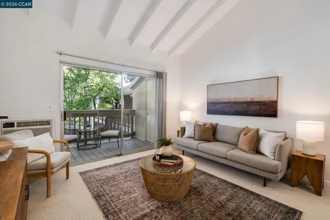 a living room with furniture and a floor to ceiling window