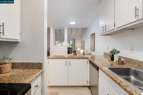 a kitchen with granite countertop a sink and cabinets