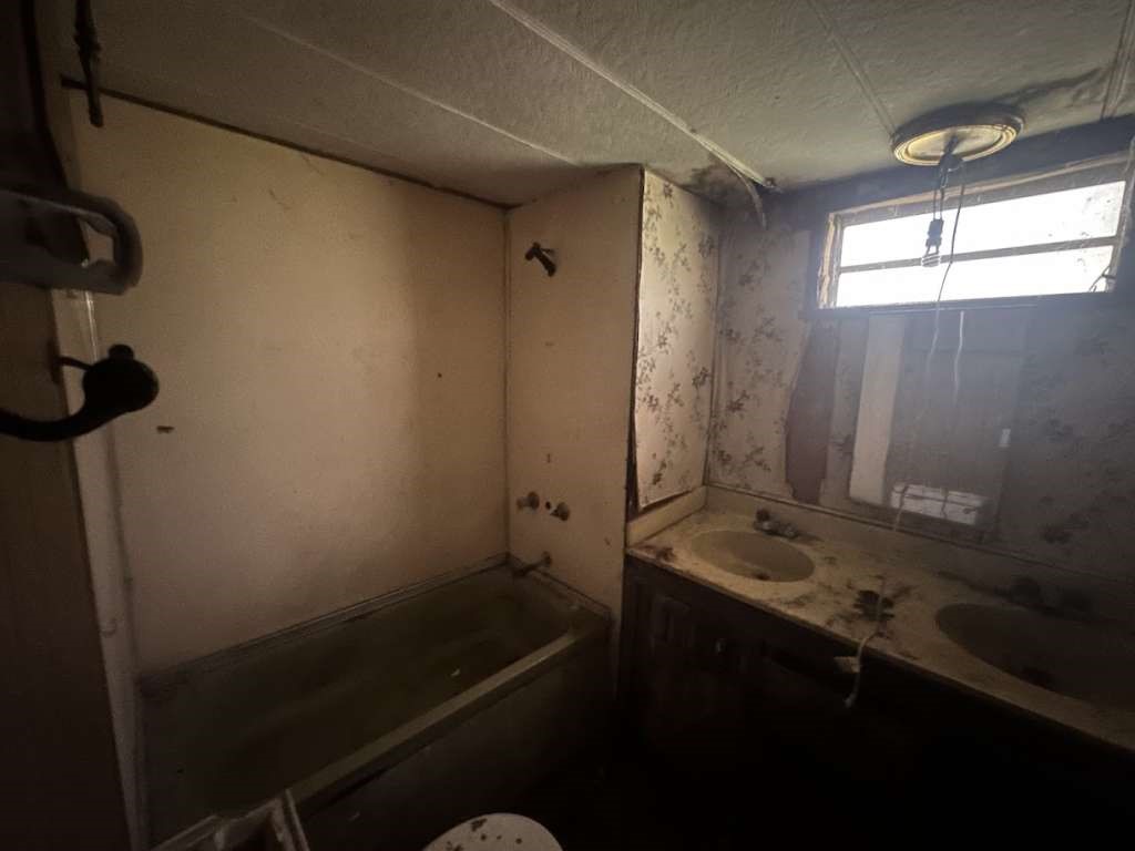 602 East Navasota Street Groesbeck, TX 76642 - Photo 5 of 13 a bathroom with a sink a toilet and shower