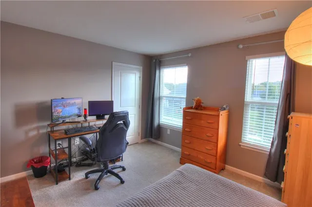 a view of a workspace with furniture and a window