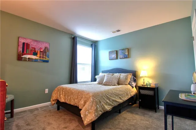 a bedroom with a bed and a painting on the wall