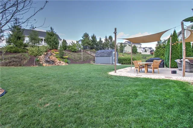 a view of a patio with table and chairs with a yard and plants