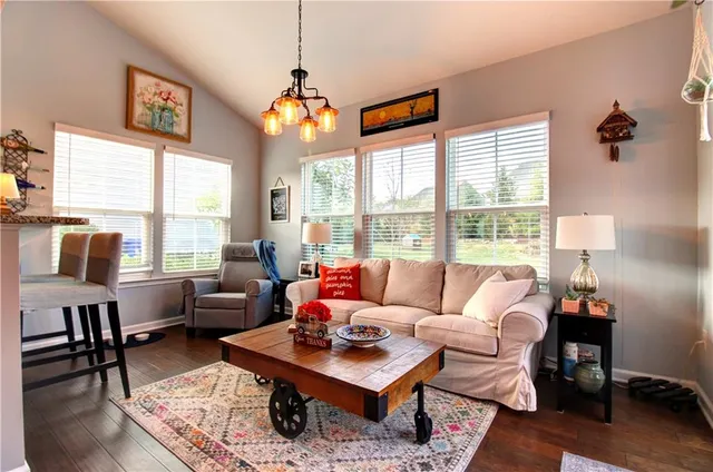 a living room with furniture a chandelier and a flat screen tv
