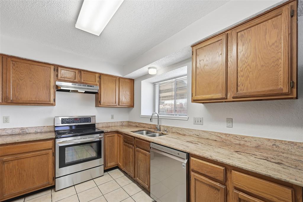 2708 Chisolm Trail Mesquite, TX 75150 - Photo 12 of 28 a kitchen with granite countertop a sink stainless steel appliances and cabinets