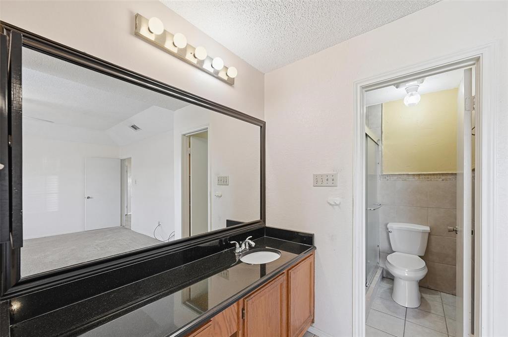 2708 Chisolm Trail Mesquite, TX 75150 - Photo 15 of 28 a bathroom with a granite countertop sink a toilet and a mirror