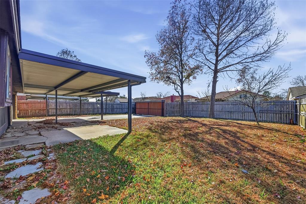 2708 Chisolm Trail Mesquite, TX 75150 - Photo 24 of 28 a view of a backyard with table and chairs under an umbrella