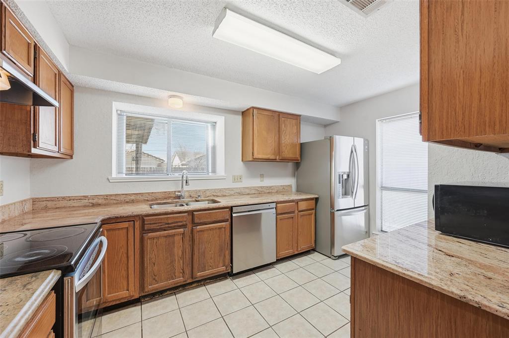 2708 Chisolm Trail Mesquite, TX 75150 - Photo 10 of 28 a kitchen with stainless steel appliances granite countertop a sink stove and refrigerator