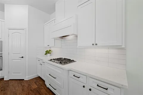 a kitchen with white cabinets and appliances