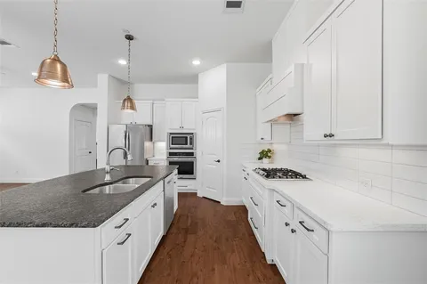 a kitchen with stainless steel appliances granite countertop a sink stove and refrigerator