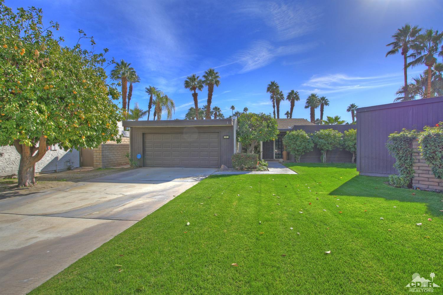 a view of a house with a yard and a tree