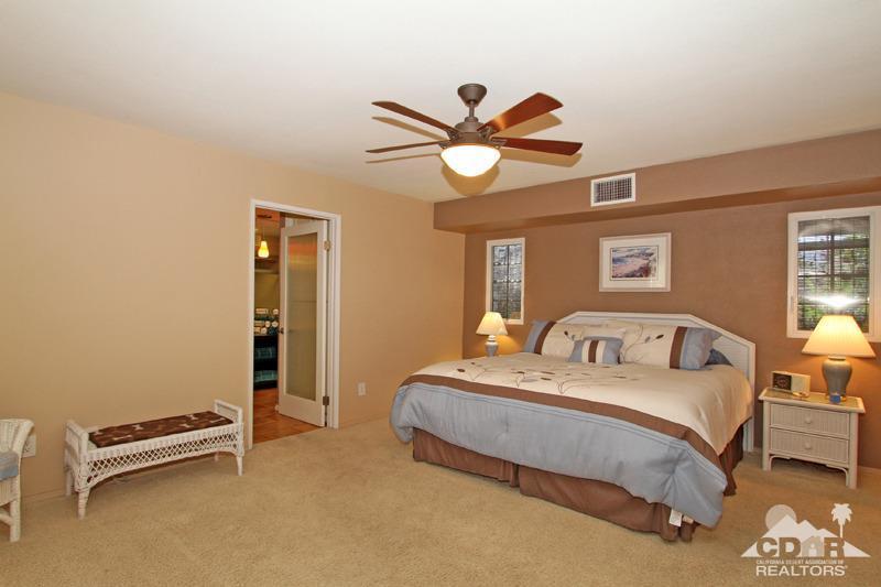 4 Kevin Lee Lane Rancho Mirage, CA 92270 - Photo 27 of 53 a bedroom with a bed and a chandelier