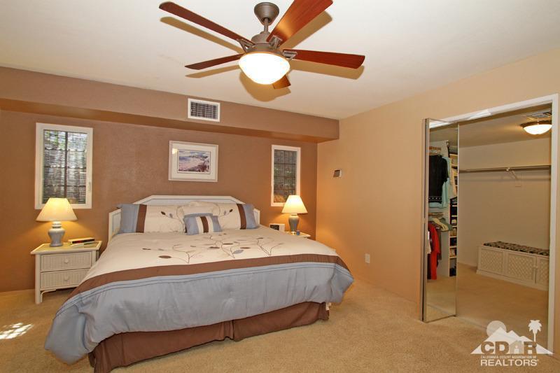 4 Kevin Lee Lane Rancho Mirage, CA 92270 - Photo 28 of 53 a bedroom with a bed and a chandelier