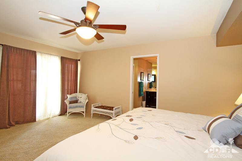 4 Kevin Lee Lane Rancho Mirage, CA 92270 - Photo 29 of 53 a bedroom with a bed and a chandelier
