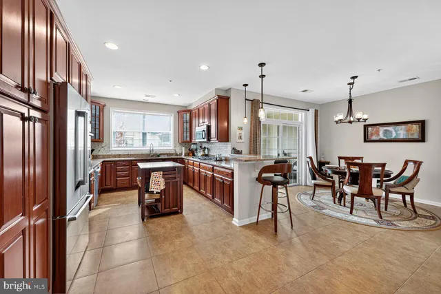 a living room with furniture kitchen view and a window