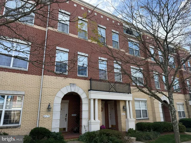 a front view of a residential apartment building with a yard