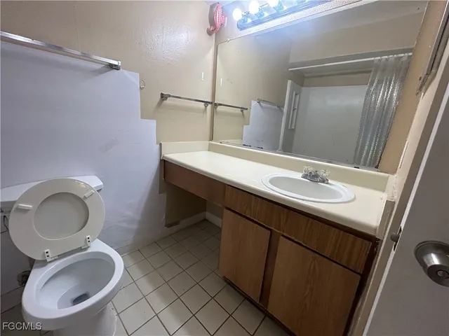 a bathroom with a sink vanity mirror and toilet