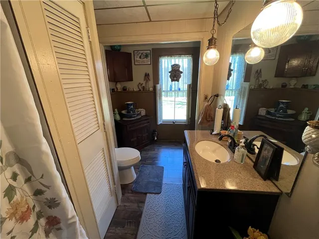 a bathroom with a sink a toilet a mirror and shower