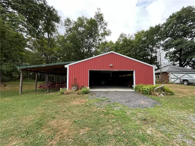 a front view of house with yard and trees in the background