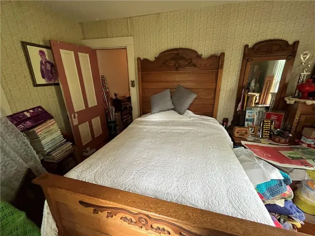 a bed sitting in a bedroom next to a window