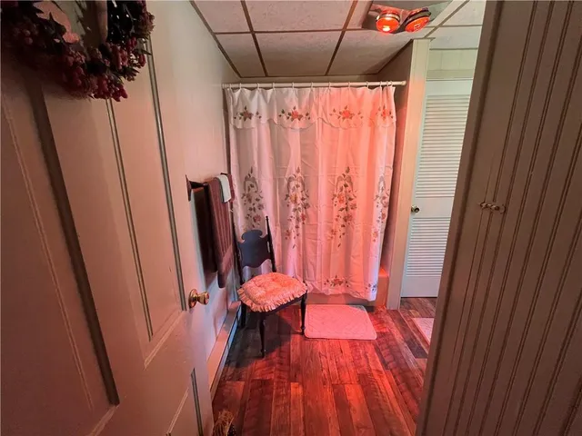 a view of a hallway with furniture and wooden floor