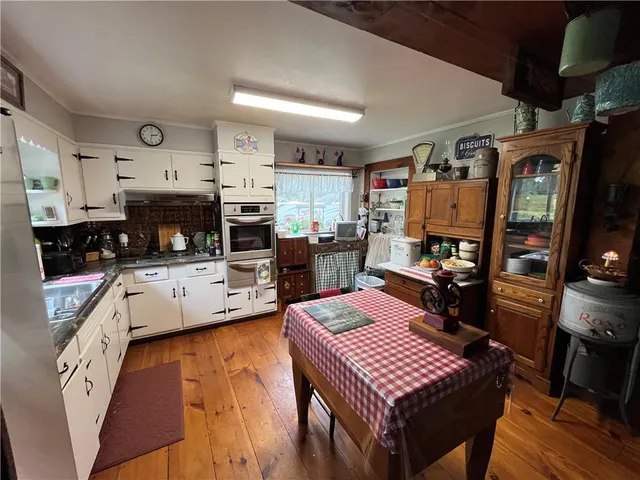 a large kitchen with cabinets table and chairs
