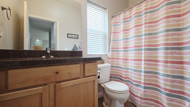 1437 925 South Vernal, UT 84078 - Photo 13 of 47 Bathroom featuring a light wood vanity with a dark countertop, a mirror, and a toilet