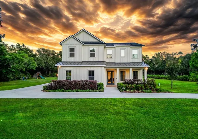 a front view of a house with a garden and yard