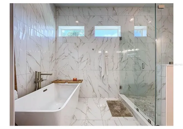 a bathroom with a sink vanity tub and a mirror
