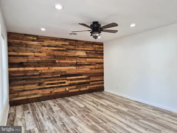 a view of room with a ceiling fan and wooden floor