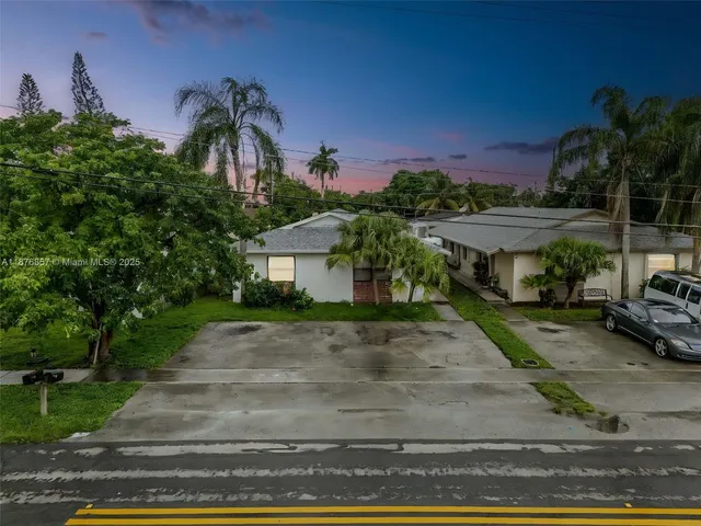 a front view of a house with a yard and potted plants