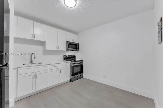 a kitchen with a refrigerator sink and microwave