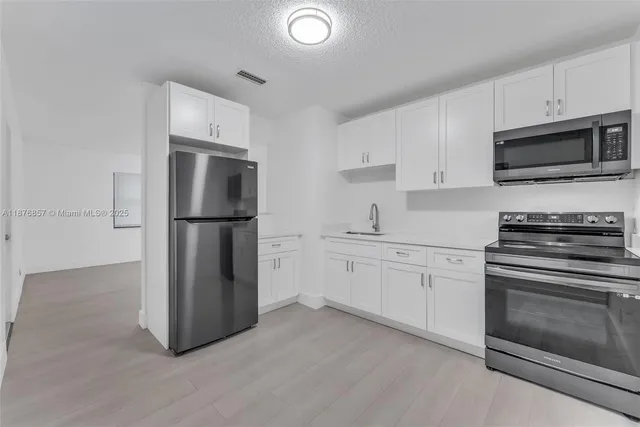 a kitchen with a refrigerator and sink