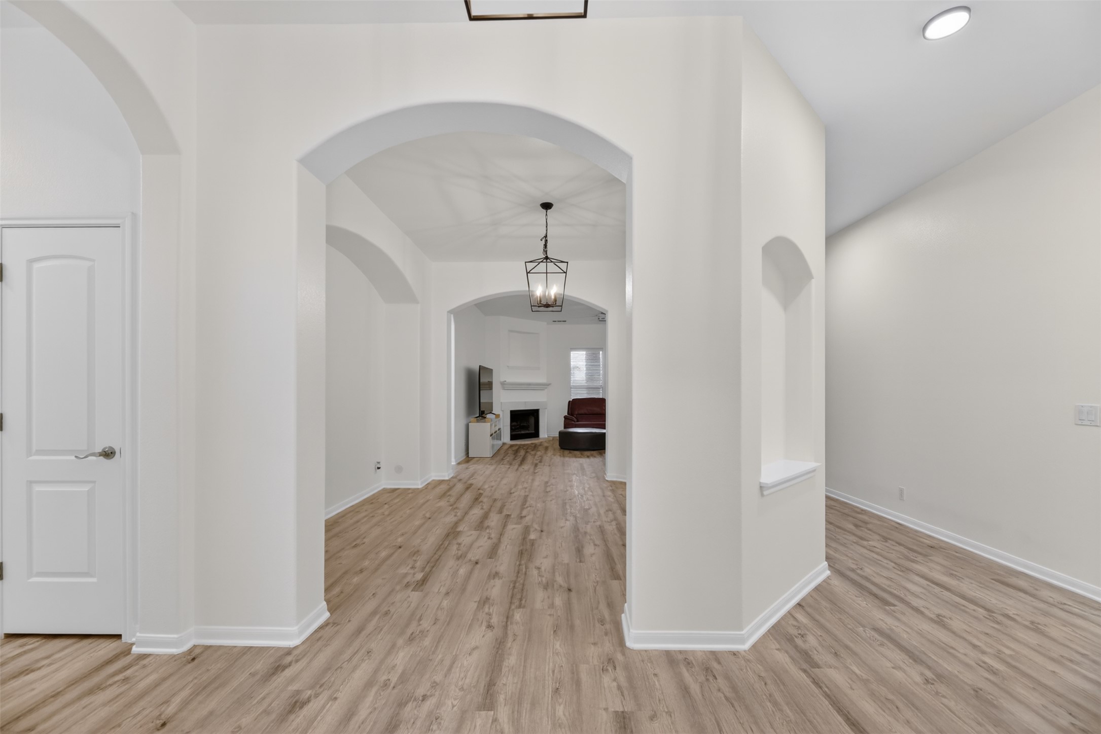 545 Manchester Lane Austin, TX 78737 - Photo 6 of 30 a view of a hallway with wooden floor and a kitchen