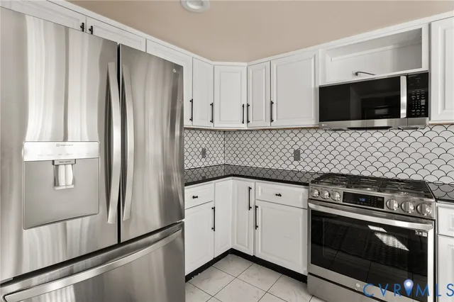a kitchen with stainless steel appliances a stove microwave and refrigerator