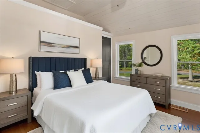 a bedroom with a bed a mirror and a large window