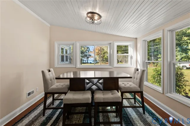 a view of a dining room with furniture a rug and wooden floor