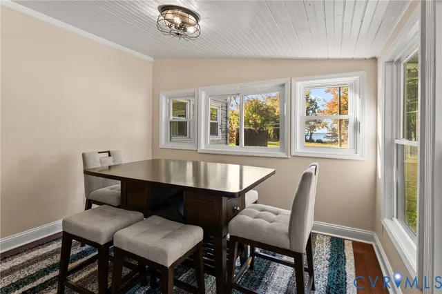 a view of a dining room with furniture a chandelier and wooden floor