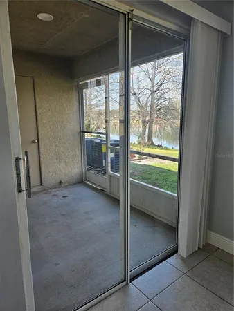 a view of an empty room with a fireplace and a window