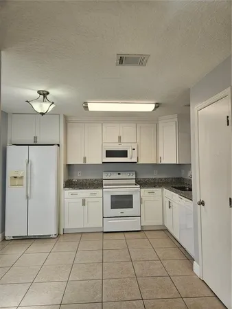a kitchen with white cabinets and white appliances