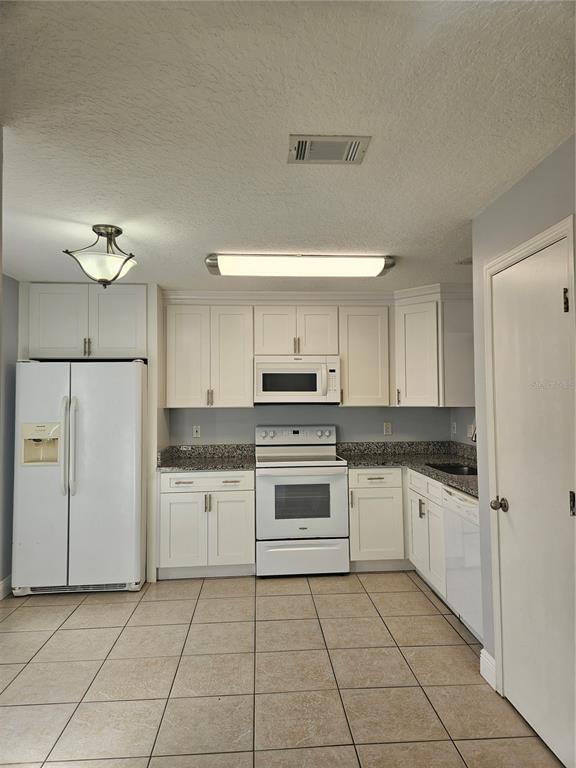 2321 Water View Loop Kissimmee, FL 34743 - Photo 2 of 41 a kitchen with white cabinets and white appliances