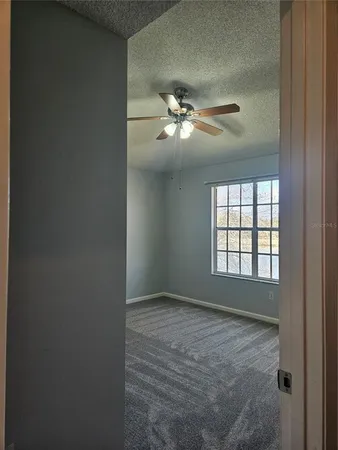 a view of an empty room with a ceiling fan