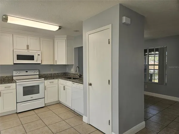a kitchen with cabinets stainless steel appliances and sink