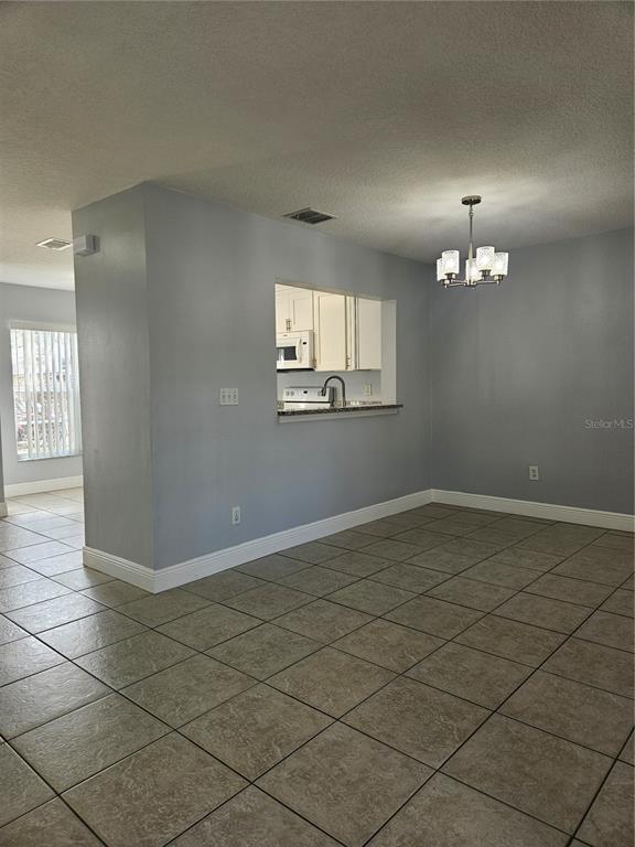 2321 Water View Loop Kissimmee, FL 34743 - Photo 7 of 41 an empty room with chandelier fan and windows