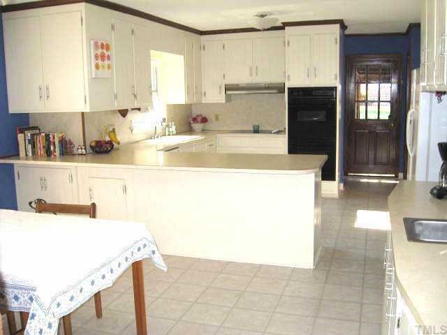 8809 Katharina Court Raleigh, NC 27613 - Photo 4 of 12 a kitchen with a sink a stove top oven and cabinets